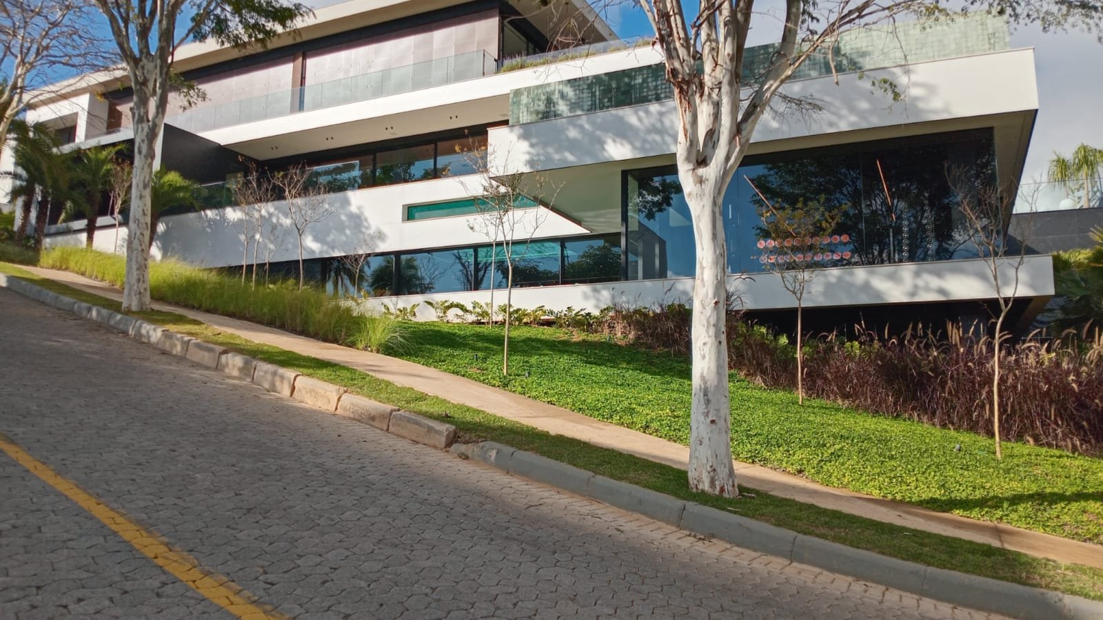 Fachada de residência de alto padrão em vidro e concreto branco